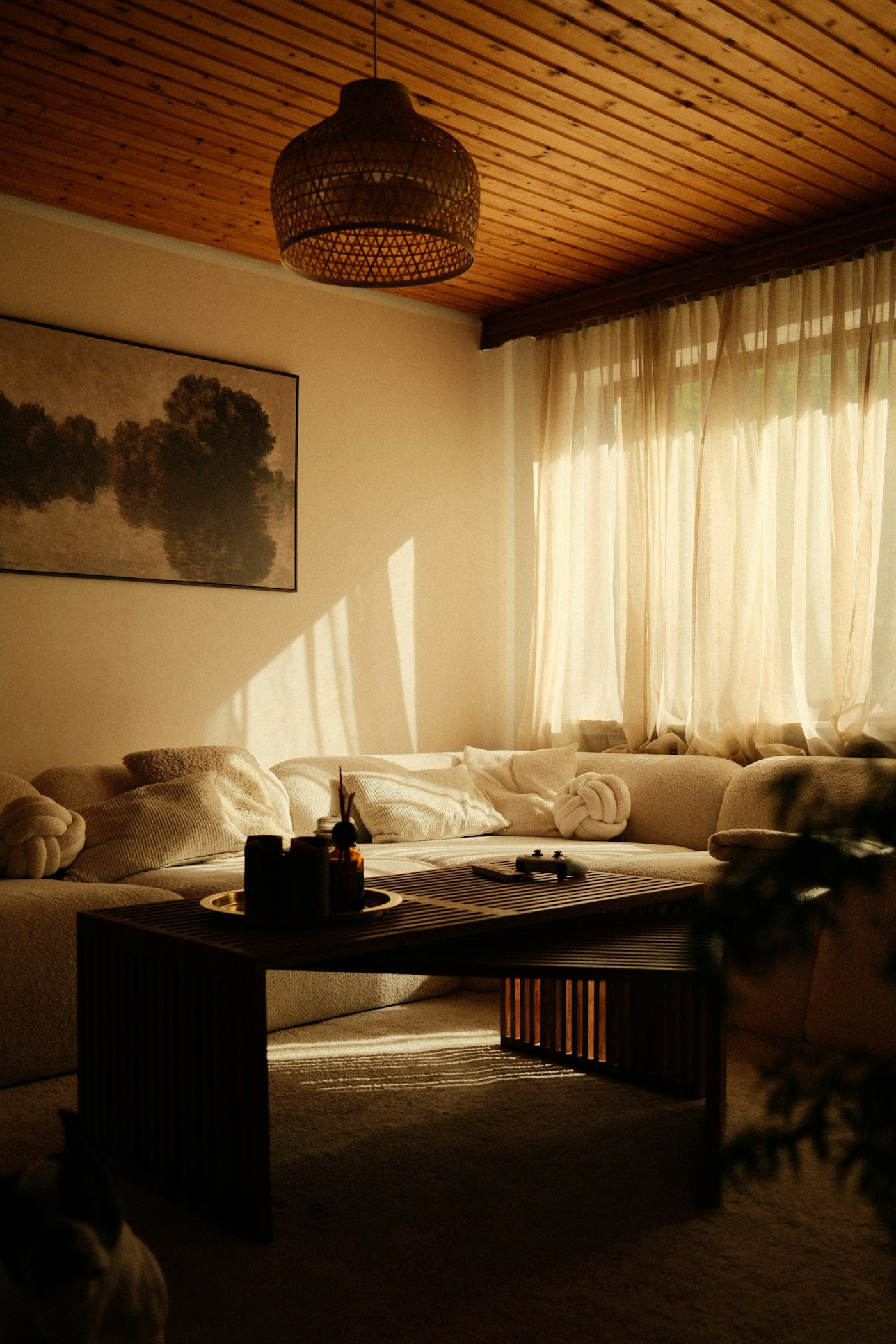 Sunlight falling across a bright living room with a cream sofa and wooden coffee table